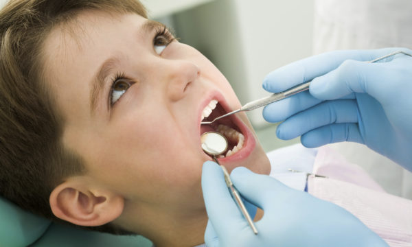 Close-up of little boy opening his mouth during dental checkup